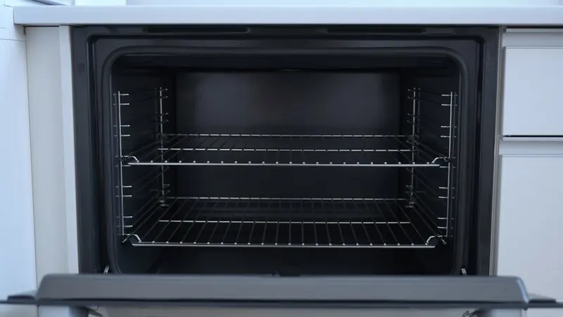 An empty oven cavity with racks, seen through the open door
